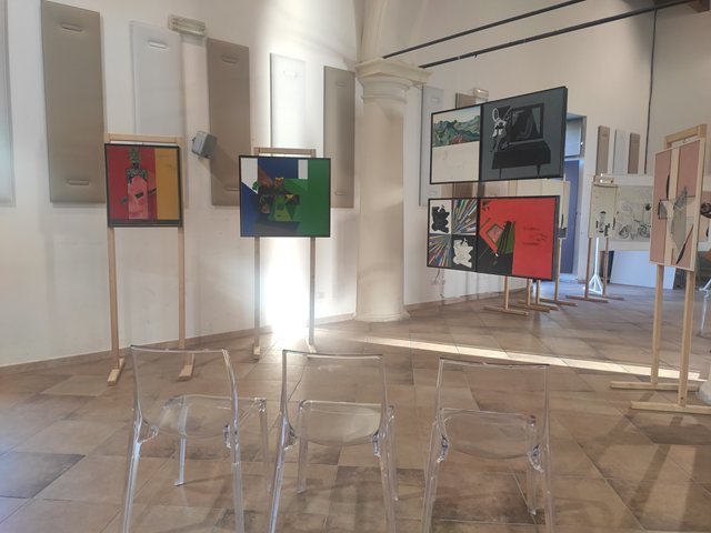 La Sala delle Colonne con opere esposte su cavalletti e pannelli